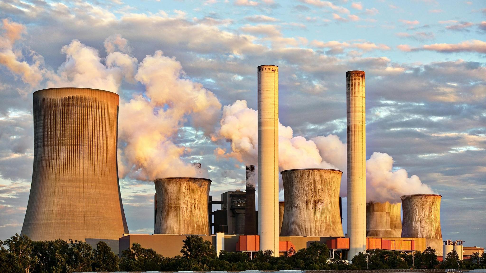 Das Bild zeigt eine Fabrik, die Emissionen ausstößt.