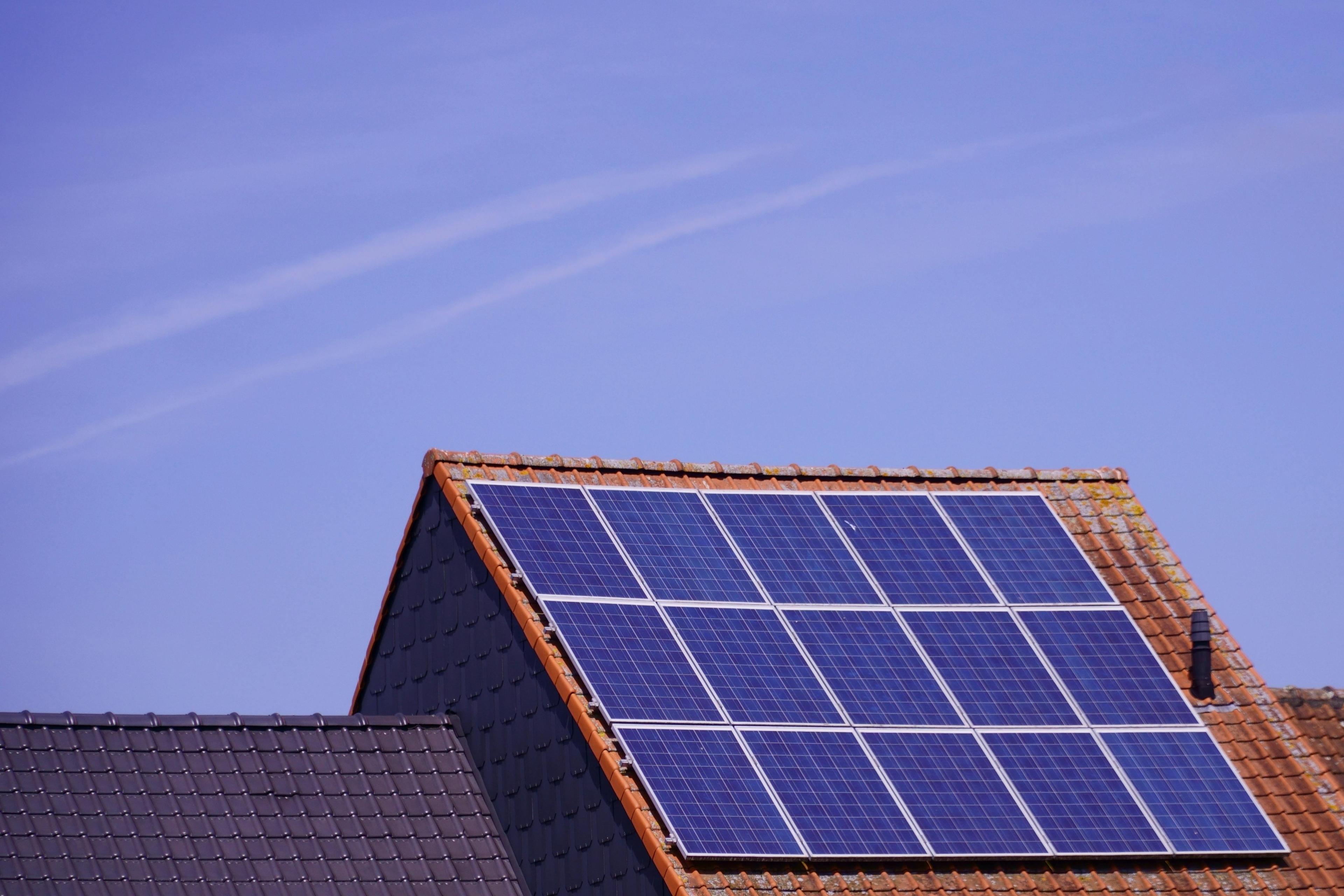 Auf dem Dach eines Hauses sind Solarpaneele installiert. 