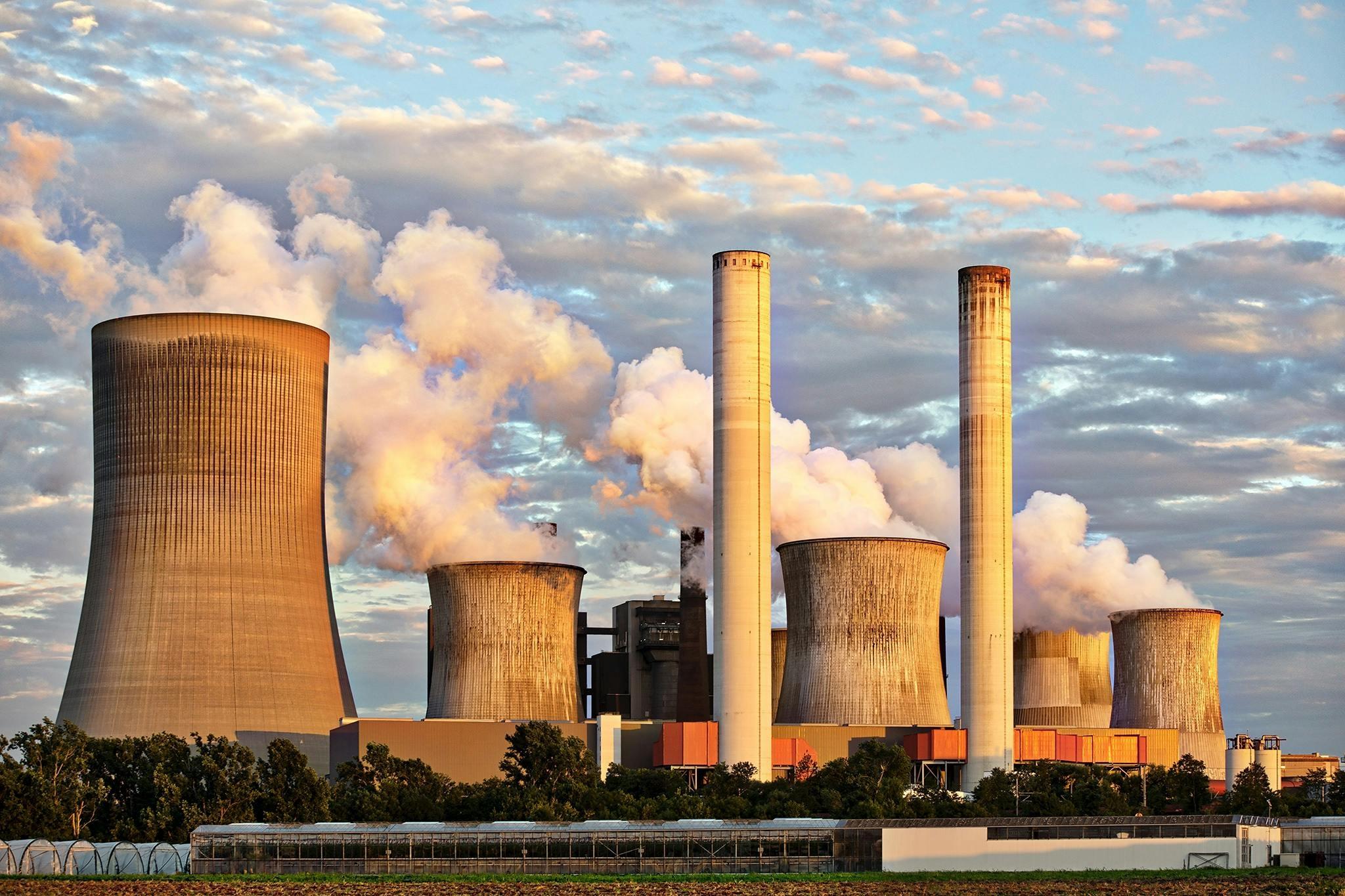Das Bild zeigt eine Fabrik, die Emissionen ausstößt.
